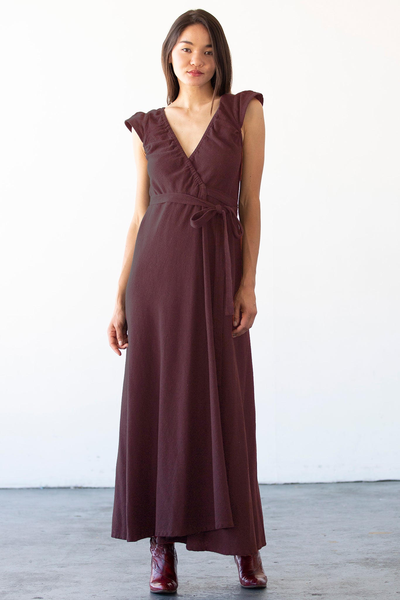 Woman wearing a darkest fig dress against a white background