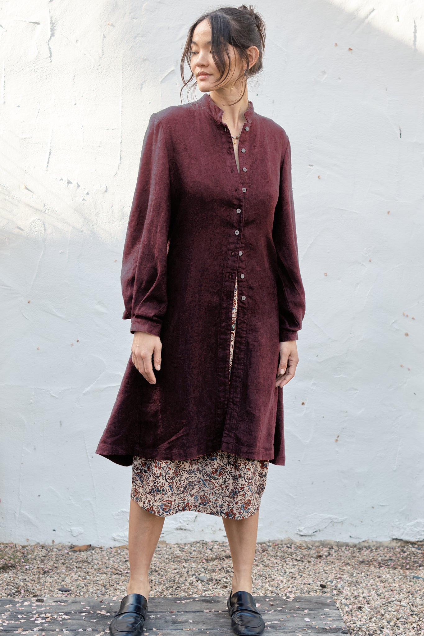 Woman wearing a burgundy cloth coat with a white background