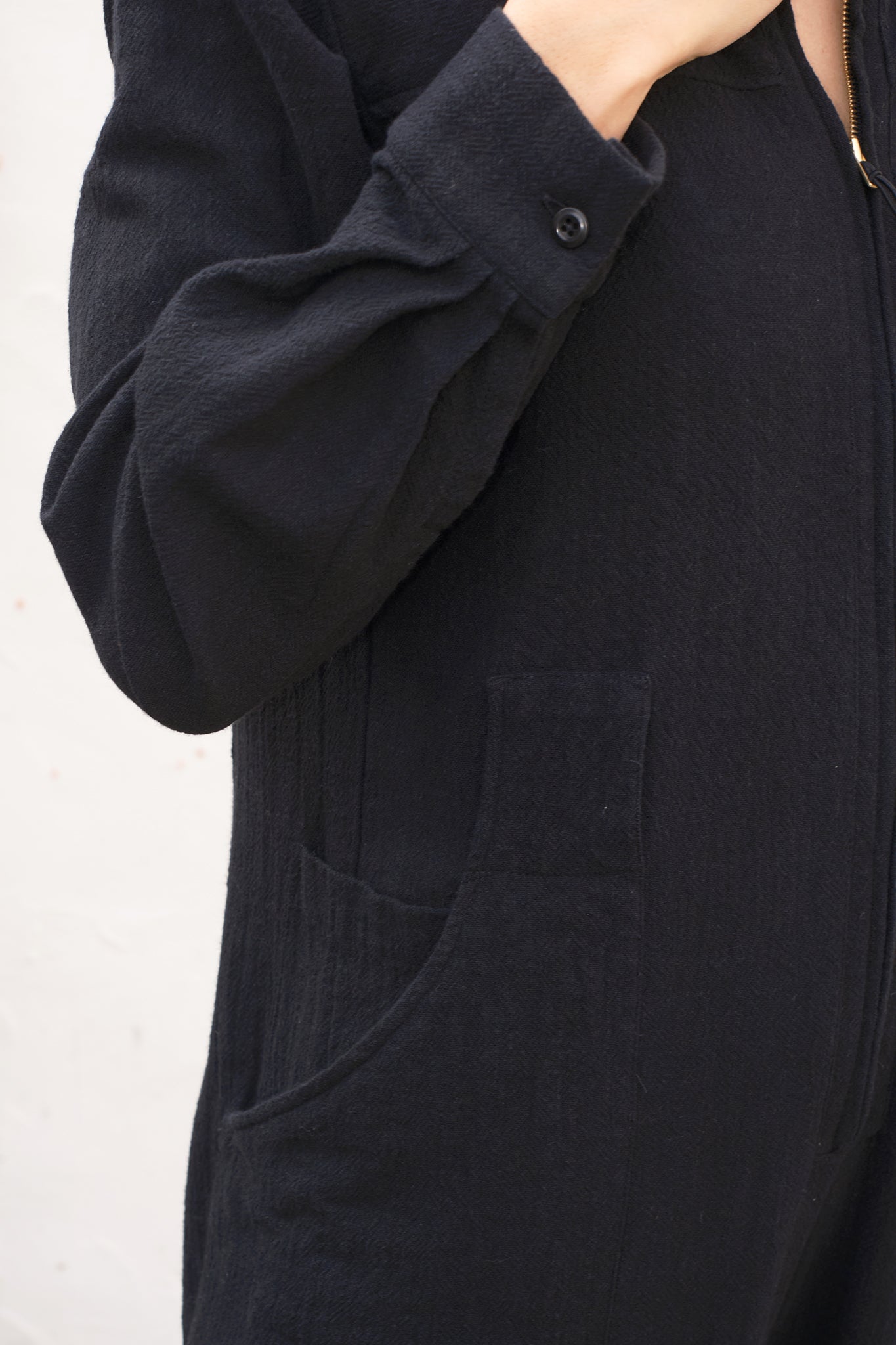 Close-up of a black jumpsuit  with a white background