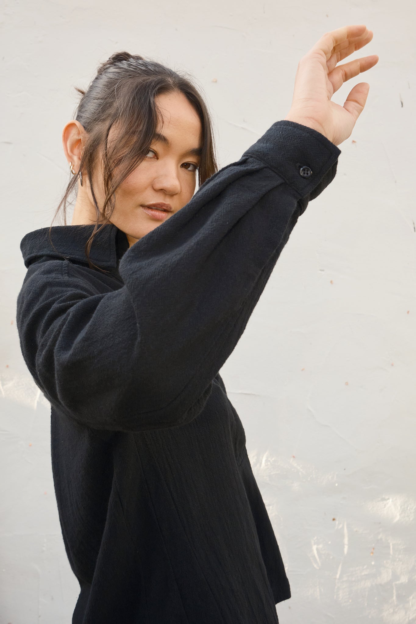 Person wearing a black shirt against a light background