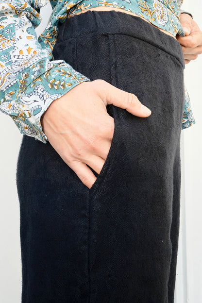 Person wearing black pants with a floral patterned shirt